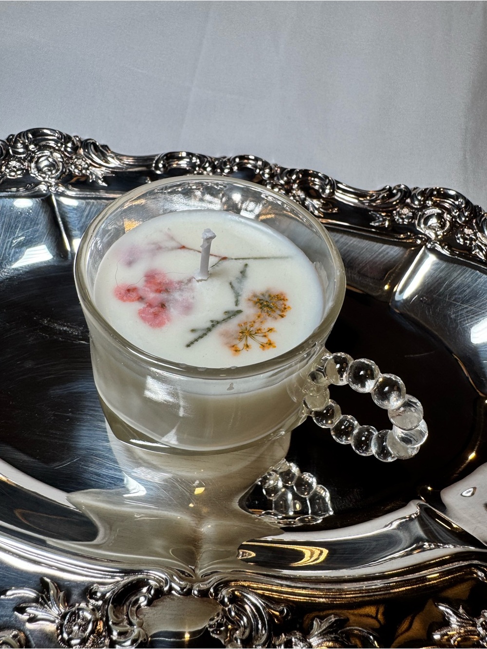 White Floral Teacup Candle in Clear Glass Cup with Beaded Handle